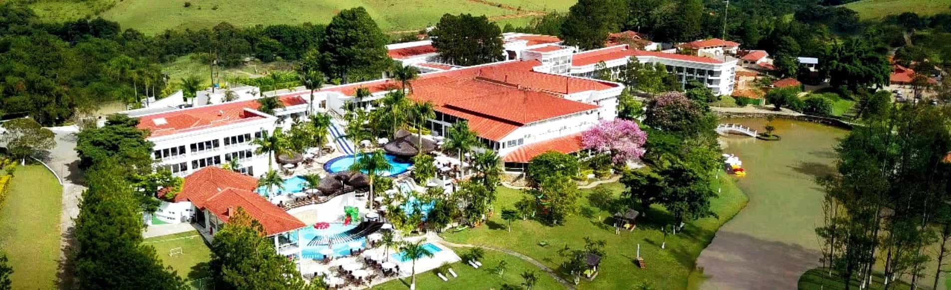 Vista panorâmica da piscina principal do Vale Suíço Resort, com as montanhas ao fundo.